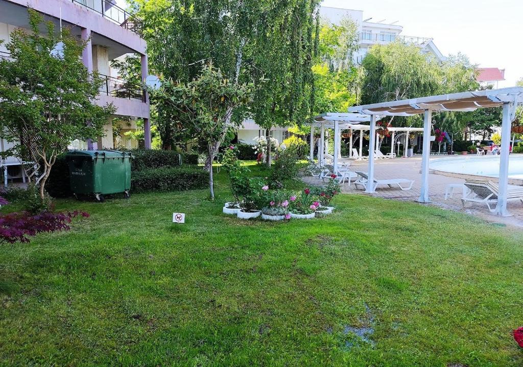 a yard with a pool and a white pergola at Charis Cozy Family apart at Sun Village Complex close to the Beach in Sunny Beach