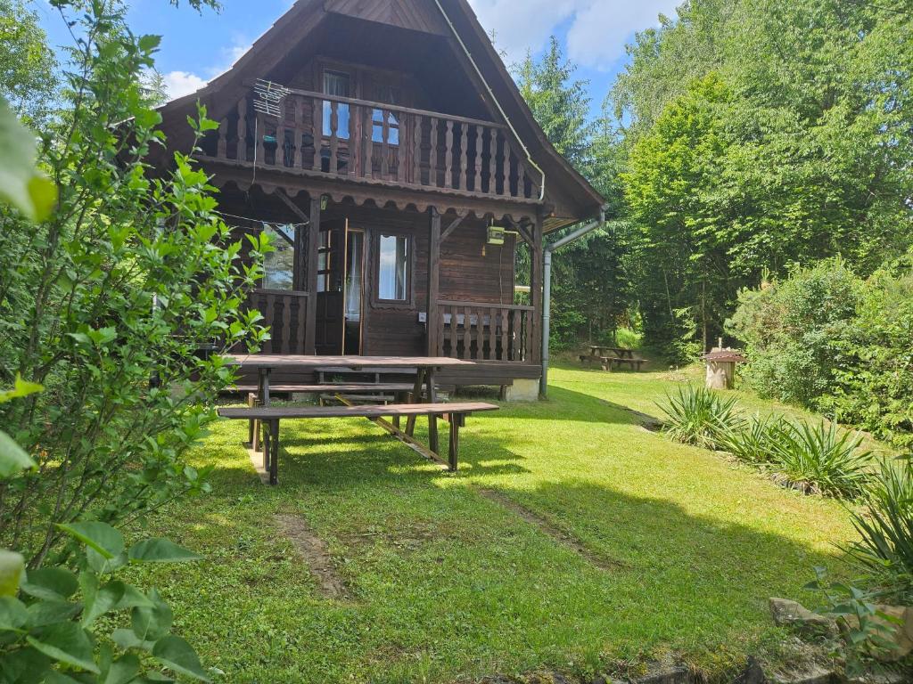 a log cabin with a picnic bench in the yard at Domek u Marysi in Bukowiec
