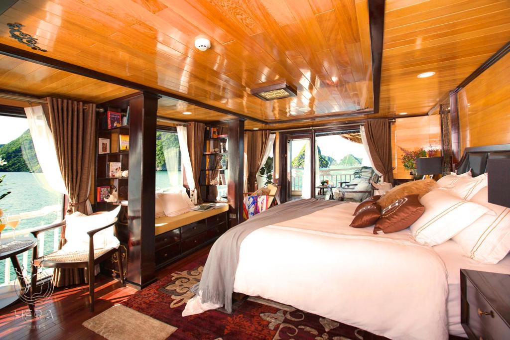 a bedroom in a boat with a bed and a desk at Hera Cruises Group on Ha Long Bay in Ha Long