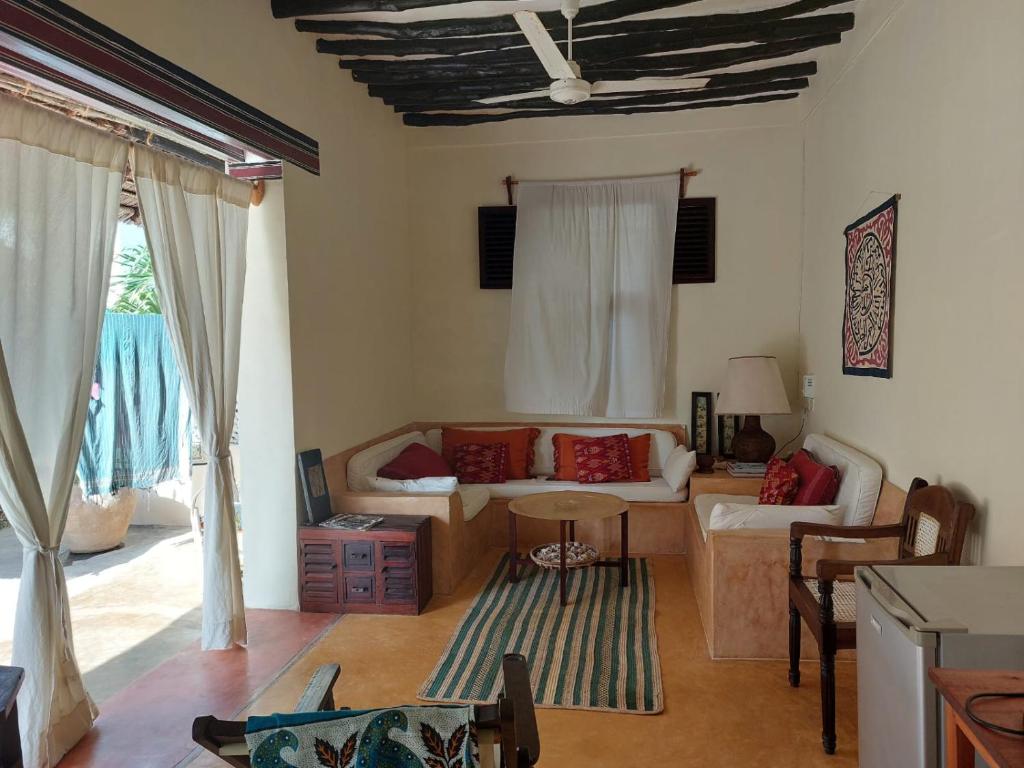 een woonkamer met een bank en een tafel bij Madakani House in Lamu