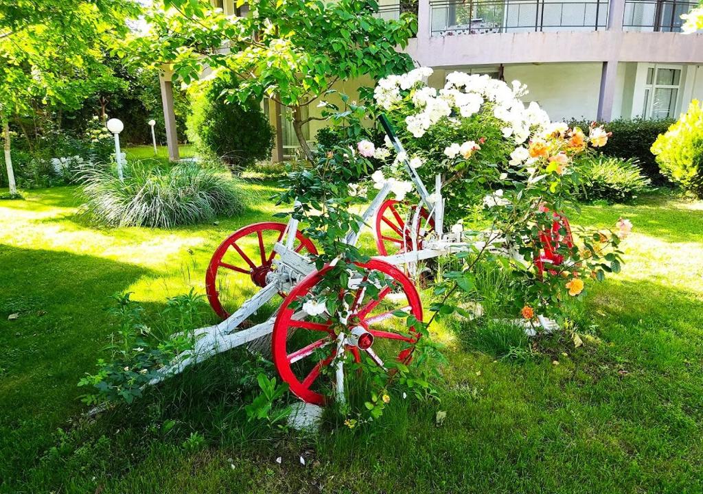 a red bicycle decorated with flowers in a yard at Charis Cozy Family apart at Sun Village Complex close to the Beach in Sunny Beach