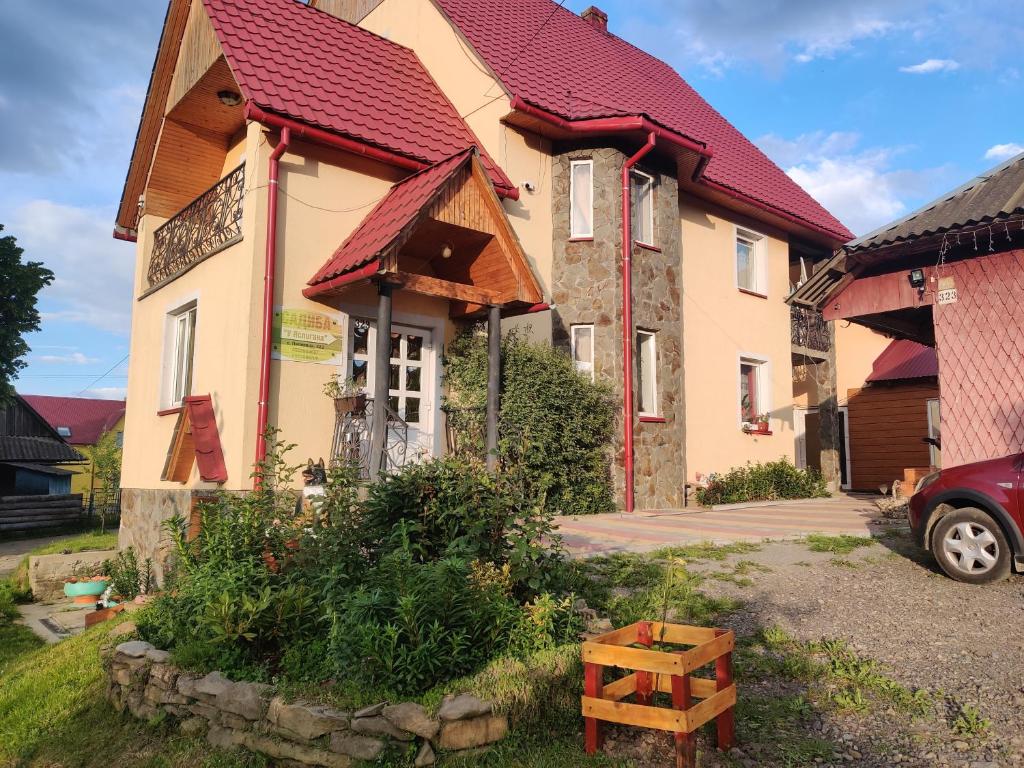 ein Gebäude mit rotem Dach und einem Haus in der Unterkunft "У Яслигана" in Pilipets