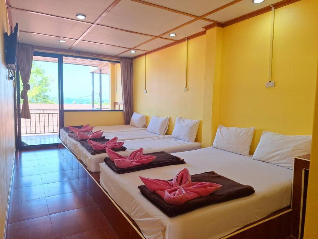 a room with four beds with pink flowers on them at Phi Phi Sand Sea View Resort in Phi Phi Islands