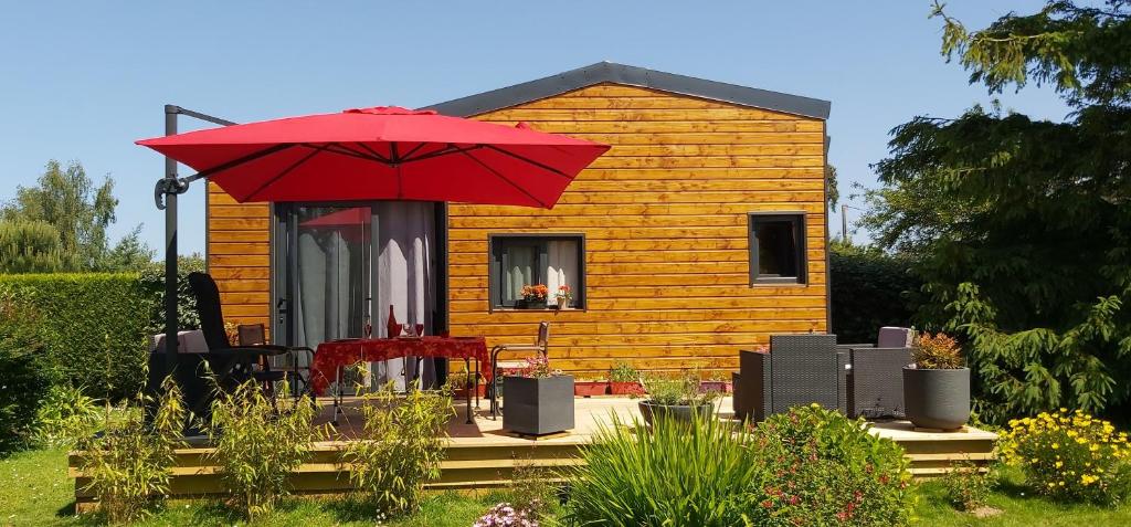 une petite maison avec un parapluie rouge devant elle dans l'établissement Tiny House, à Plouézec