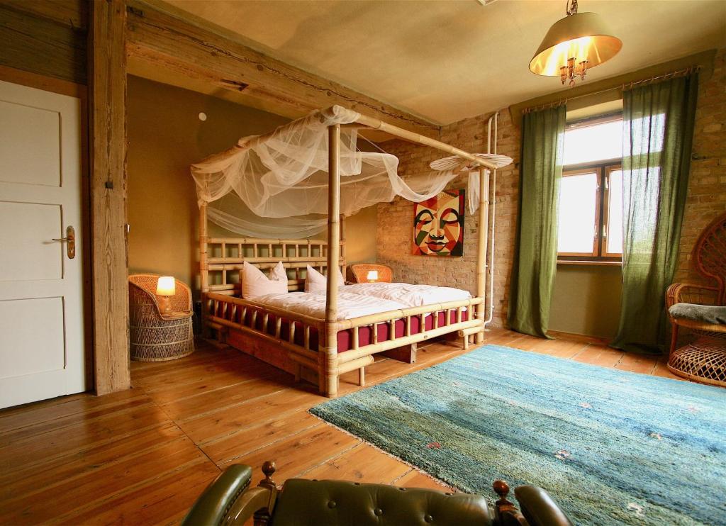 een slaapkamer met een hemelbed en een tapijt bij Kornspeicher Himmelpfort in Pian