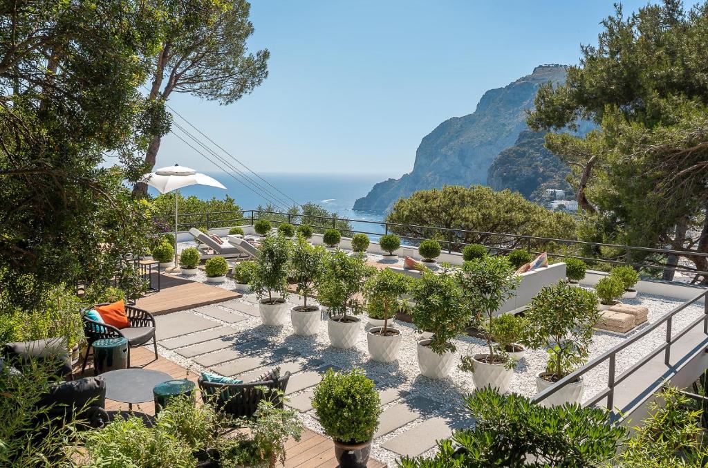 a row of potted plants on a balcony overlooking the ocean at Villa Arabella in Capri