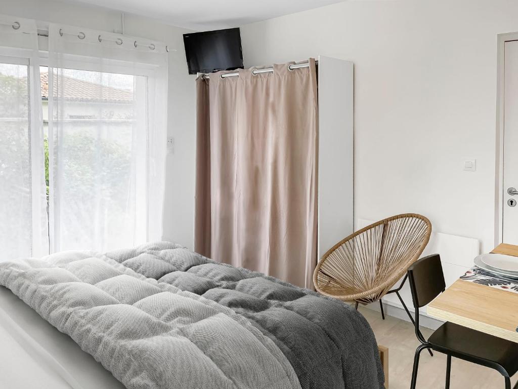 a large bed in a room with a window at Studio entre Bordeaux et l&#39;Atlantique in Saint-Médard-en-Jalles
