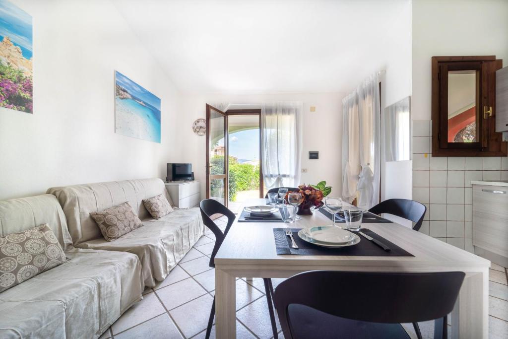 una sala de estar con una mesa y un sofá en Giardino con Vista Mare, en Codaruina