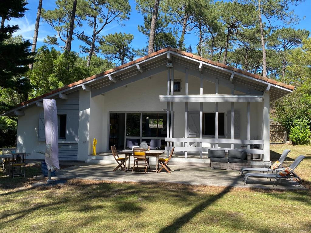 a small white house with a table and chairs at Villa Dreamland à Seignosse océan in Seignosse
