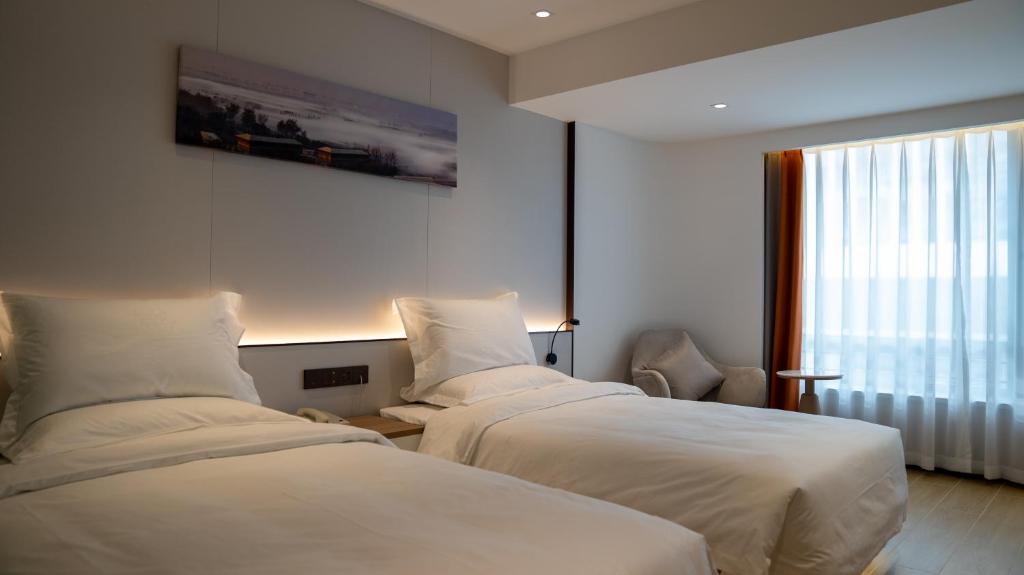 Postel nebo postele na pokoji v ubytování Yun Qi Hotel