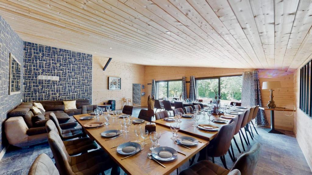 une grande salle à manger avec une longue table et des chaises dans l'établissement Cornillières Maisonnettes 35 pers jacuzzi, jeux, à Tessy-sur-Vire