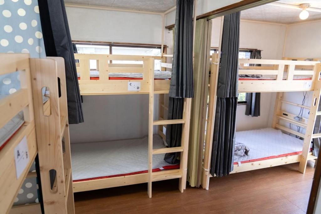 a room with three bunk beds in a dorm room at Kinoie guesthouse 3rd buildingーVacation STAY 26705v in Mito