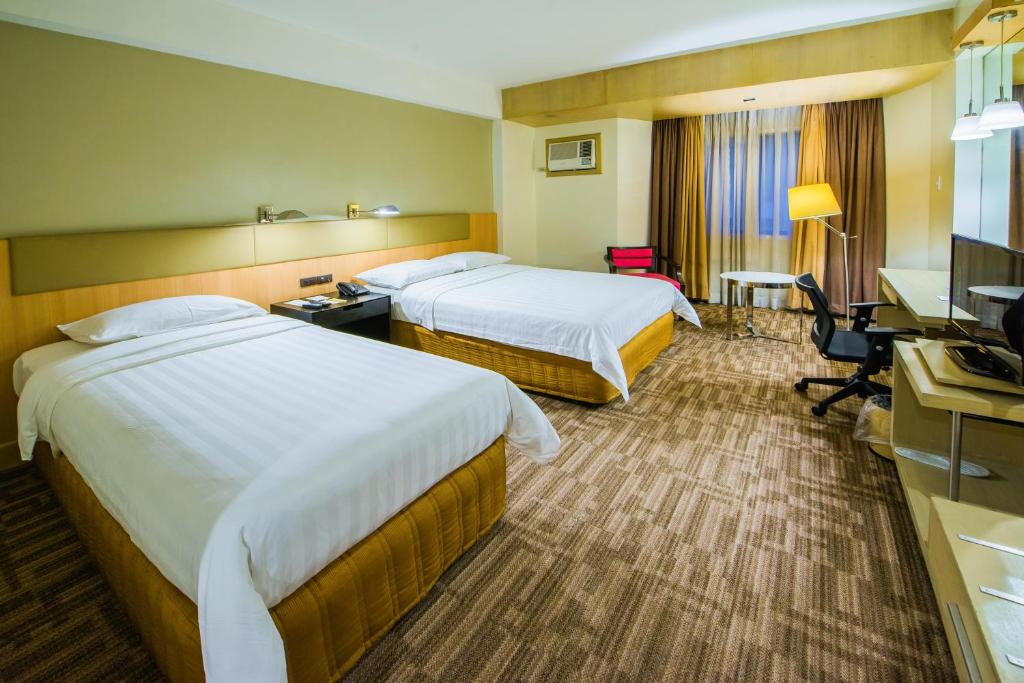 Postel nebo postele na pokoji v ubytování L'Fisher Hotel Bacolod