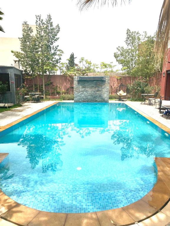 a large swimming pool with blue water at Splendide Villa, Marrakech in Marrakesh