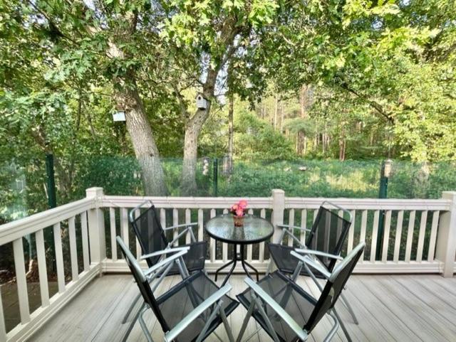 a patio with a table and chairs on a deck at Forest View at Oakdene Forest Park - Leisure Passes Included! in Ringwood