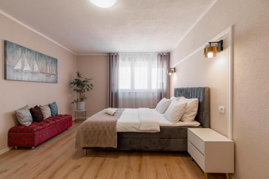 1 dormitorio con 1 cama grande y 1 sofá rojo en Apartment Ivica, en Zadar