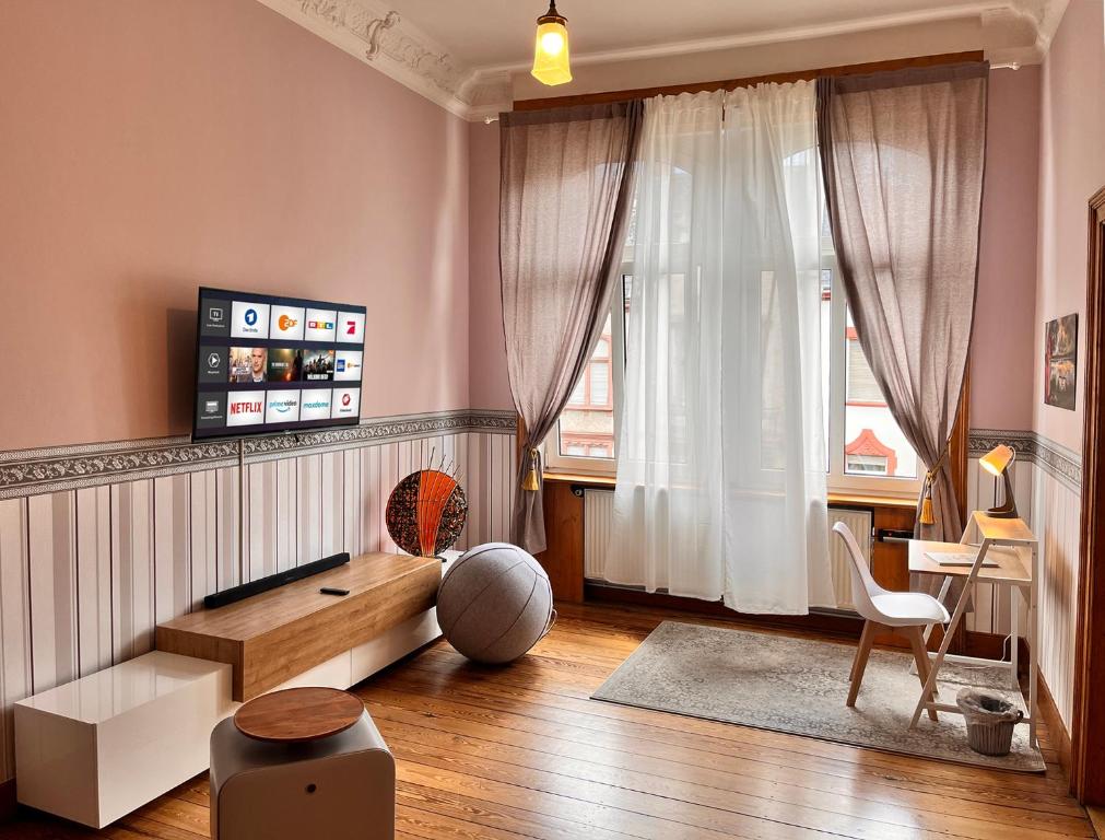 ein Wohnzimmer mit einem Sofa und einem Fenster in der Unterkunft Apartment am Schloss-Park Wiesbaden Biebrich am Rhein in Wiesbaden
