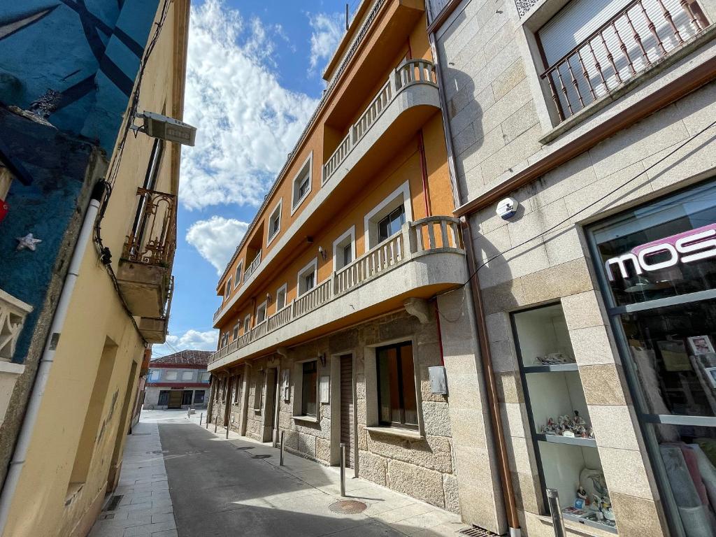 un edificio con balcones al lado de una calle en Complejo Tamanaco Illa de Arousa 3000, en A Illa de Arousa