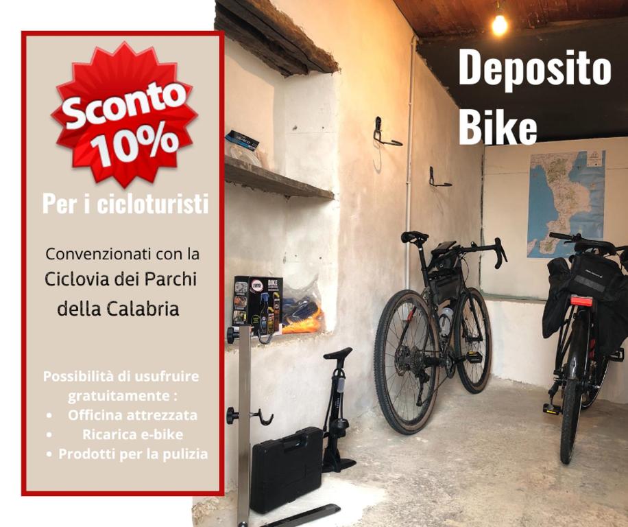 uma placa com duas bicicletas estacionadas ao lado de uma parede em Risveglio nel Borgo em San Donato di Ninea