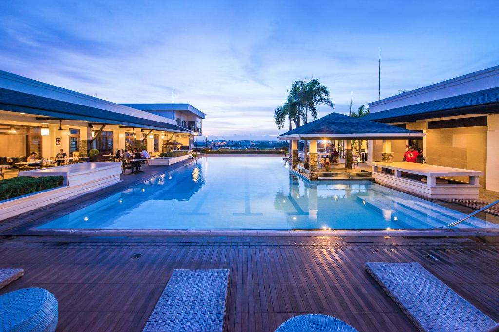 a large swimming pool in a building with a resort at L'Fisher Hotel Bacolod in Bacolod