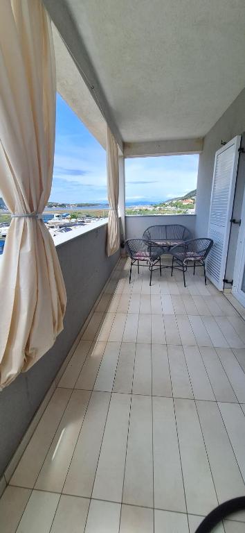 d'un balcon avec une table et des chaises et une vue sur l'océan. dans l'établissement Apartman Belisima Deluxe, à Rab