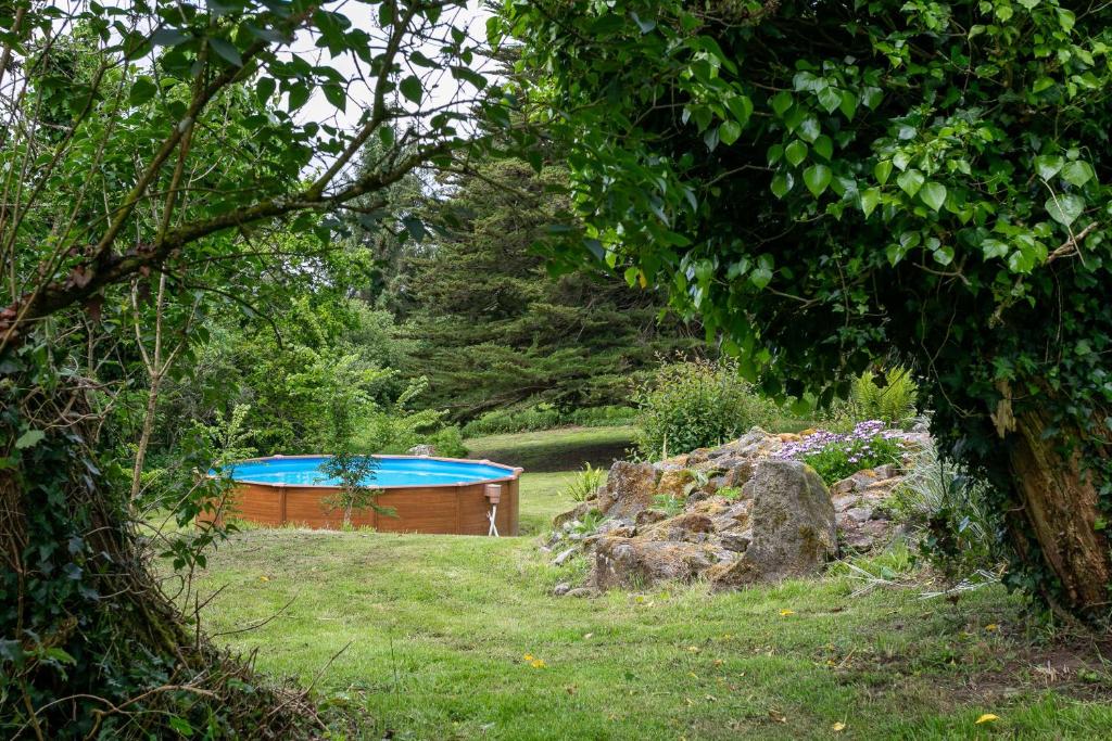 une baignoire dans une cour avec un jardin dans l'établissement Gîte Le Cornouaille - 8 personnes, à Plounérin