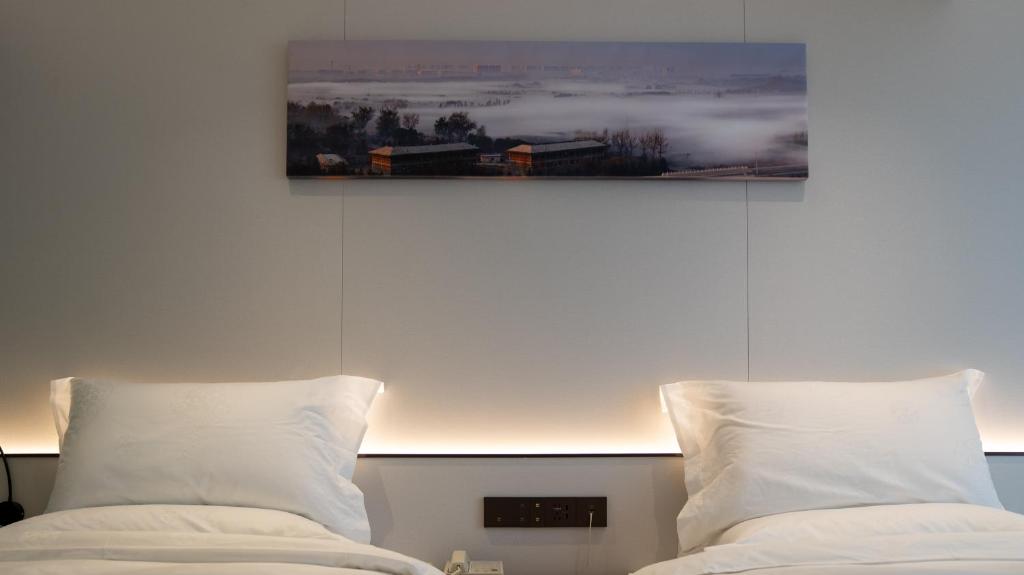 Postel nebo postele na pokoji v ubytování Yun Qi Hotel