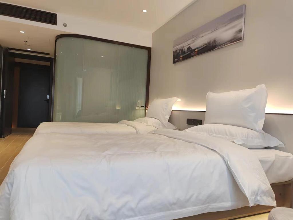 Postel nebo postele na pokoji v ubytování Yun Qi Hotel