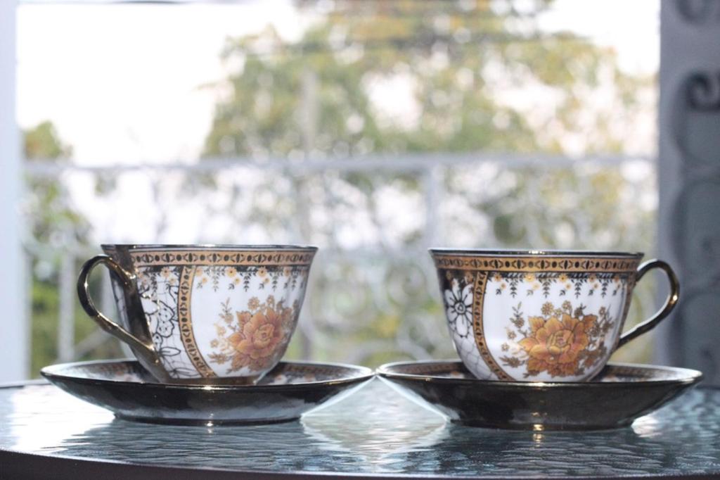 two cups sitting on a table with a plate at Epoca Iquitos in Iquitos