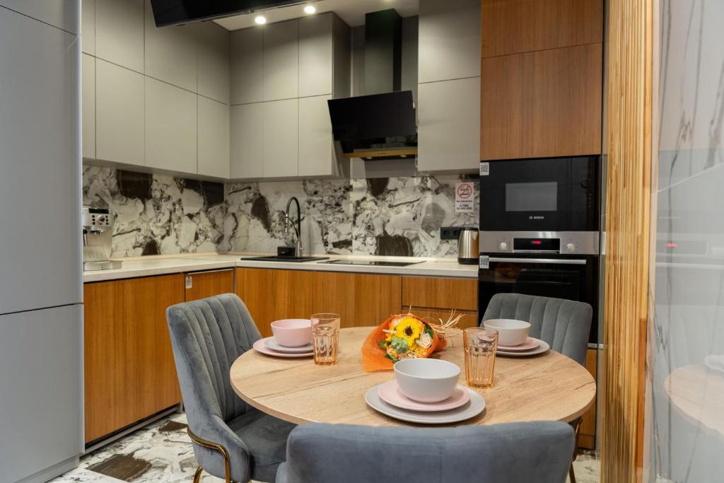 a kitchen with a wooden table and chairs in a kitchen at Arch Apart Hotel in Yerevan