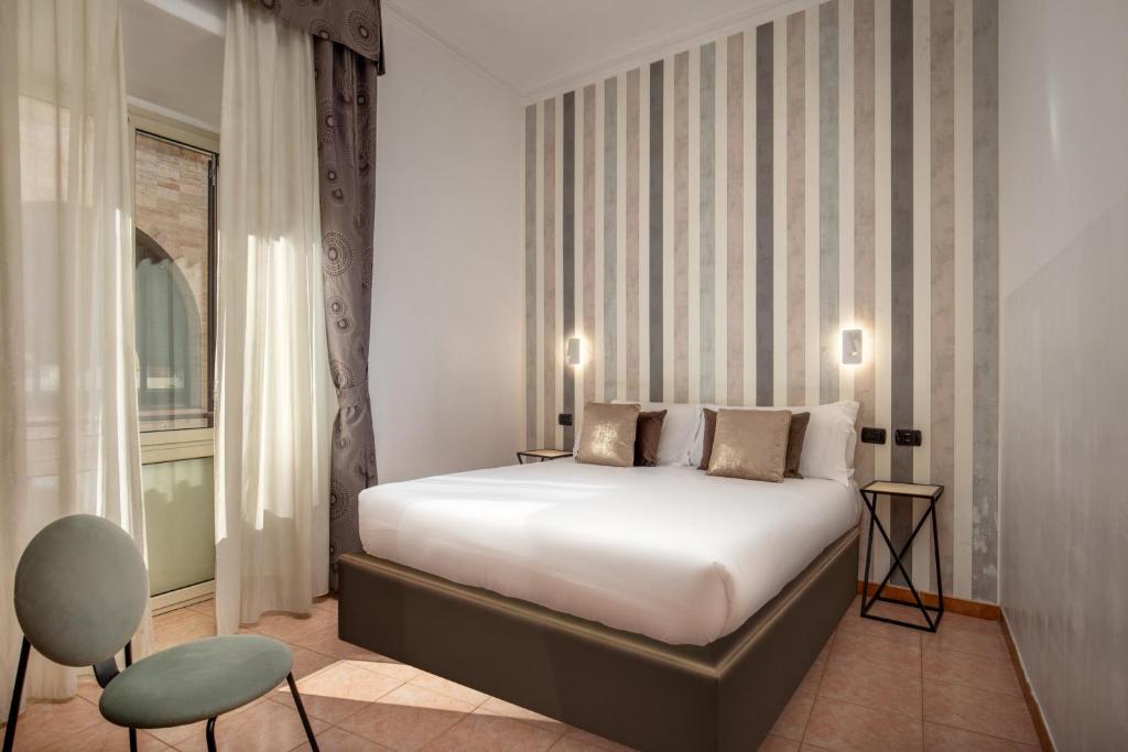 een slaapkamer met een bed, een stoel en een raam bij Hotel Ciao in Rome