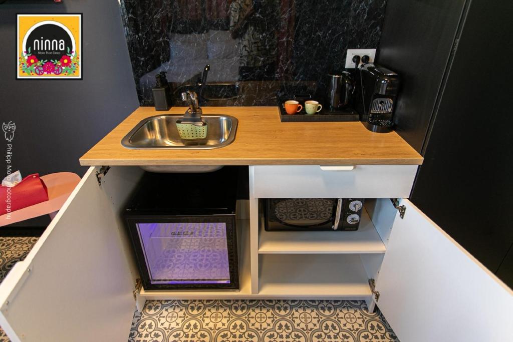 uma cozinha em miniatura com um lavatório e um balcão em Ninna palatin em Haifa