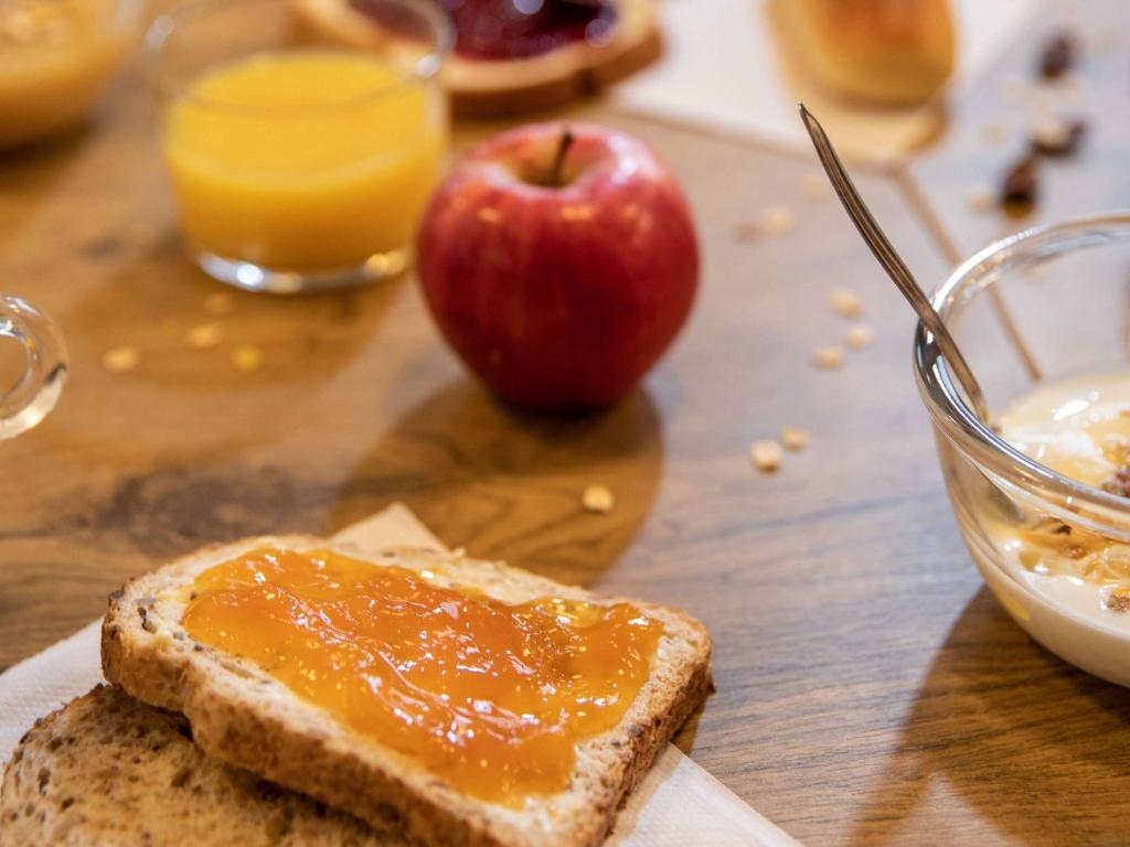 a piece of bread with jam and an apple on a table at hotelF1 N&icirc;mes Ouest in N&icirc;mes