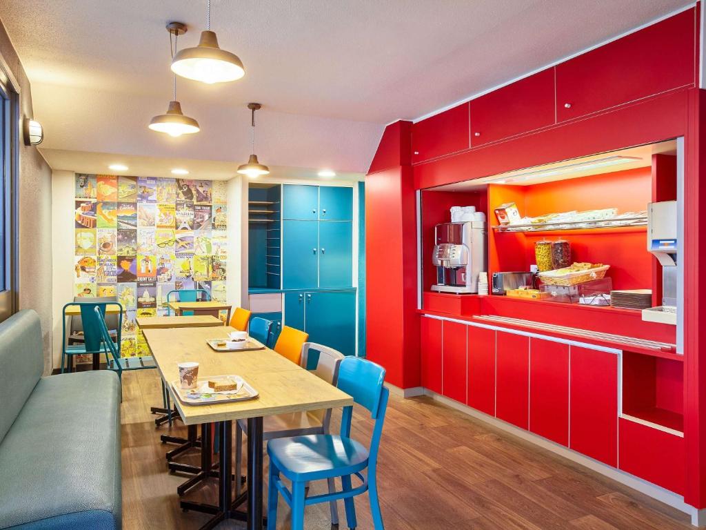 - une salle à manger avec des armoires rouges, une table et des chaises dans l'établissement hotelF1 Avignon Centre Courtine gare TGV, à Avignon