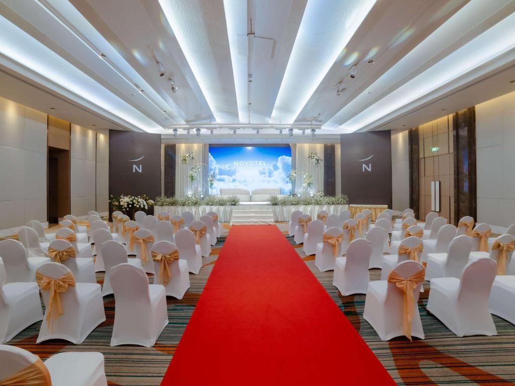 a banquet hall with white chairs and a red carpet at Novotel Phuket City Phokeethra in Phuket Town