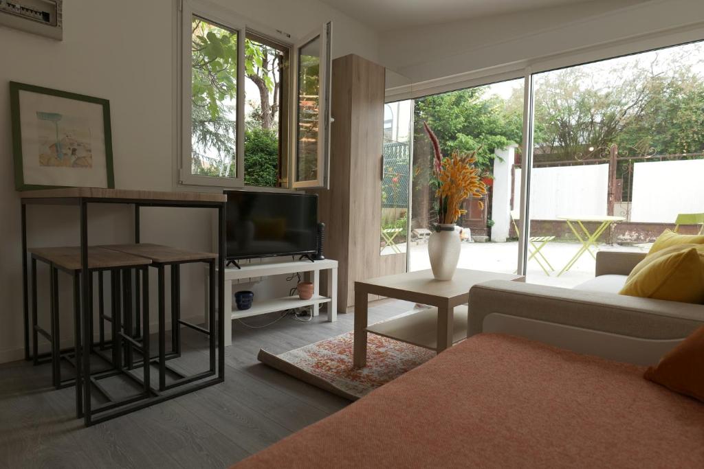 un salon avec un canapé et une télévision dans l'établissement Charmant studio lumineux à Chaville, à Chaville