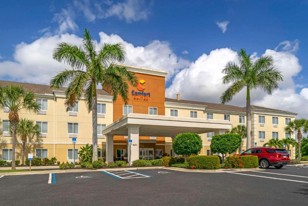 サラソタにあるComfort Suites Sarasota-Siesta Keyの駐車場前のヤシの木があるホテル