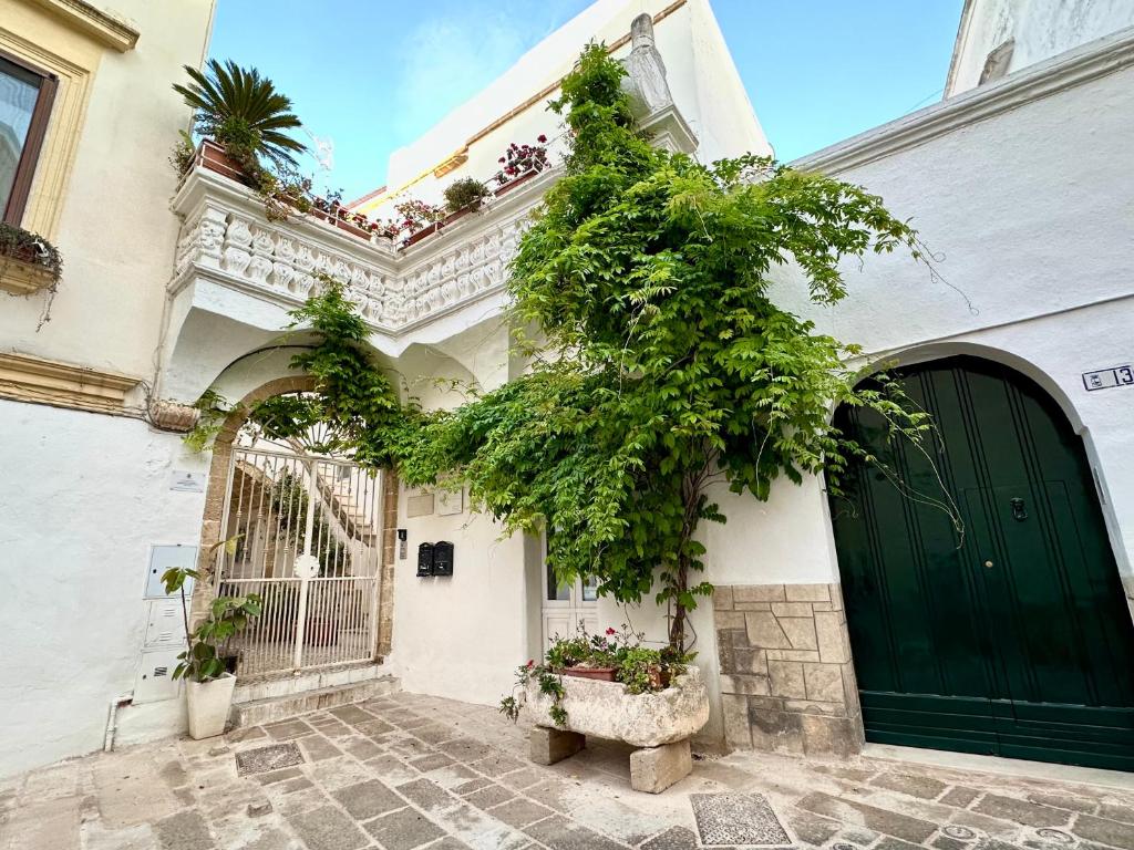 un edificio con una porta verde e una pianta di Palazzo Piccioli a Gallipoli
