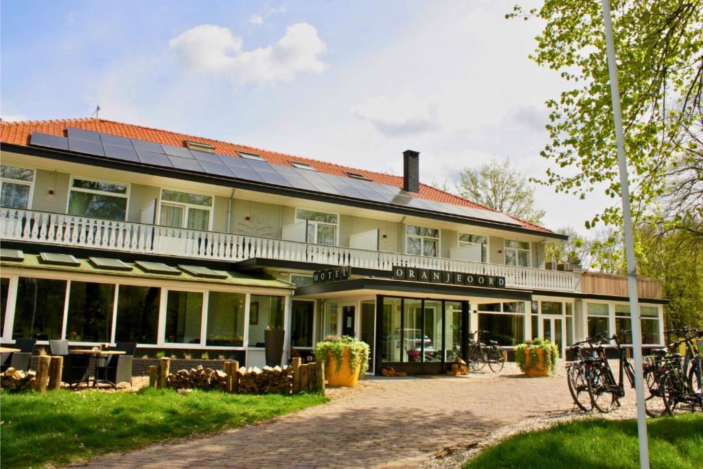un grand bâtiment avec des panneaux solaires dans l'établissement Hotel Oranjeoord, à Apeldoorn