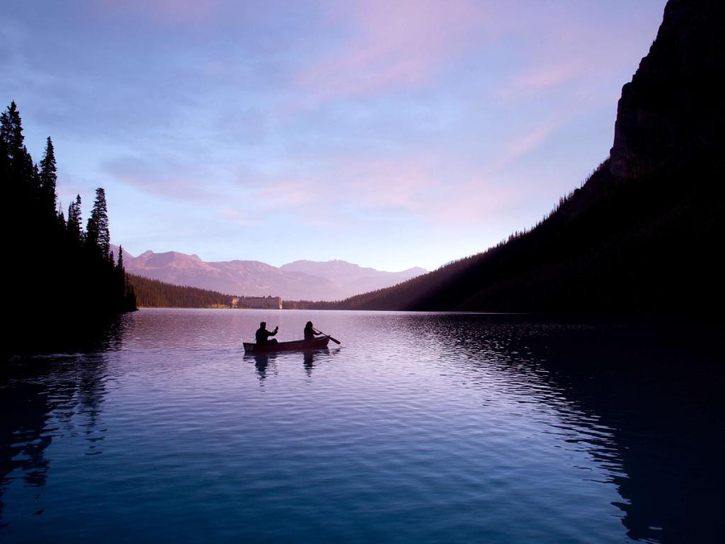 twee mensen in een boot op een meer bij Fairmont Château Lake Louise in Lake Louise