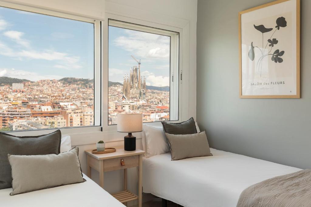 een slaapkamer met 2 bedden en een groot raam bij Click&Flat Luxury Tetuan in Barcelona