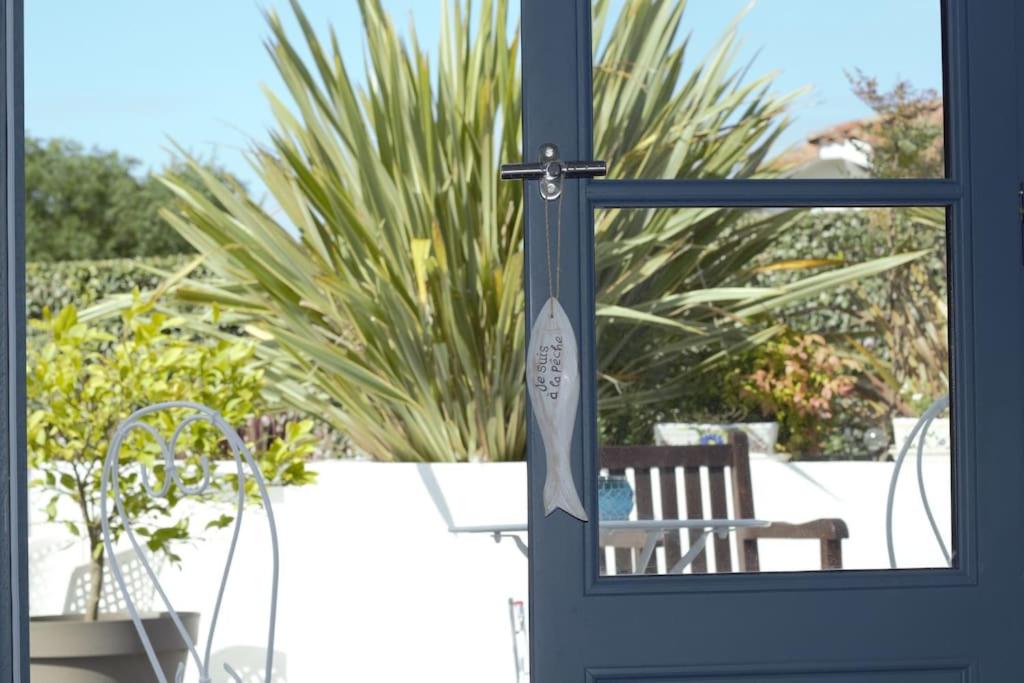 une porte bleue avec un banc devant une plante dans l'établissement Cap Océan-Studio, à Capbreton