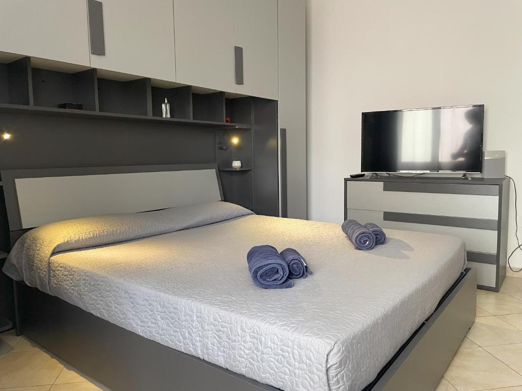 Un dormitorio con una cama con toallas moradas. en Seaside Holidays, en Alghero