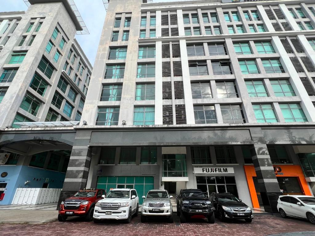een groep auto's geparkeerd voor een gebouw bij Capital O 90985 Margo Hotel KK in Kota Kinabalu