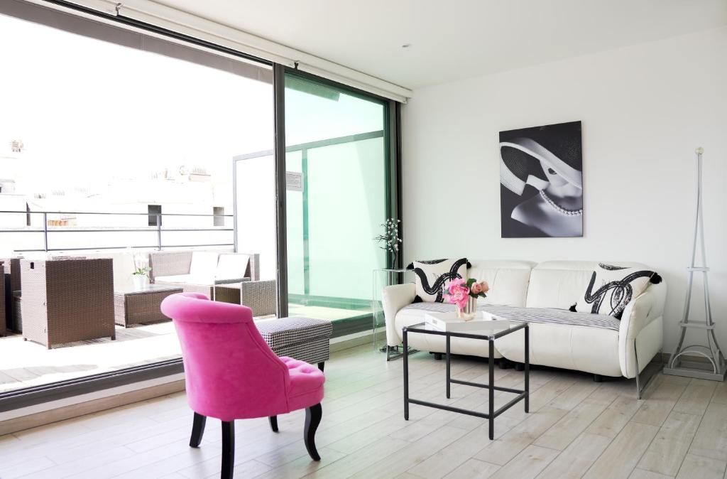 - un salon avec une chaise rose et un canapé dans l'établissement La Major du Sud proche Vieux-Port, à Marseille