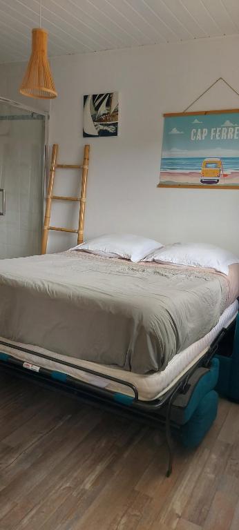 una cama sentada en una habitación junto a una pared en Mignon petit appartement indépendant en Mérignac
