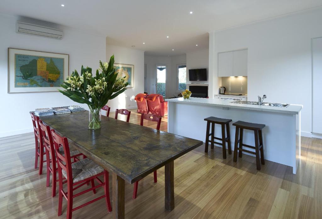 a dining room and kitchen with a table and chairs at The Cottage at Bolobek in Macedon