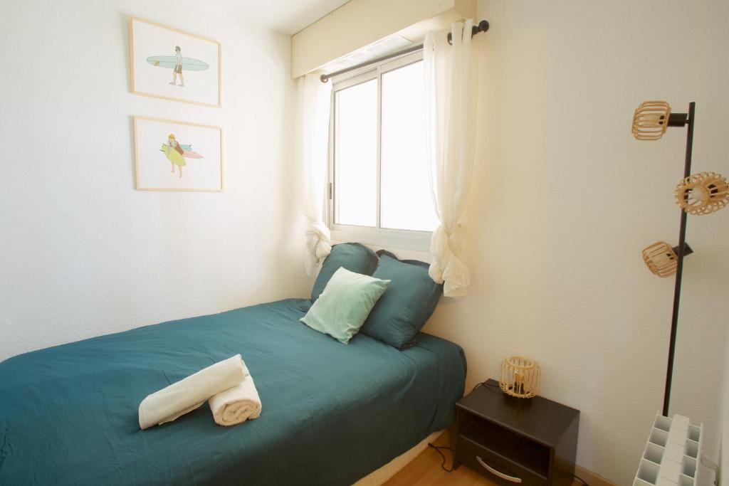 una camera con un letto blu e una finestra di Capbreton - CERS - Plage - Famille - Couple a Capbreton