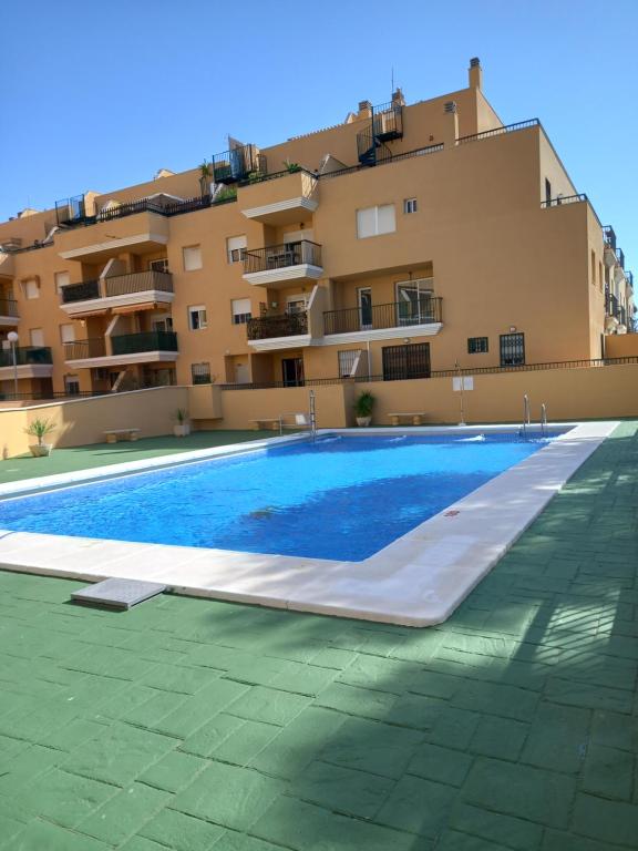 a large swimming pool in front of a building at Apartamento Golf in Roquetas de Mar