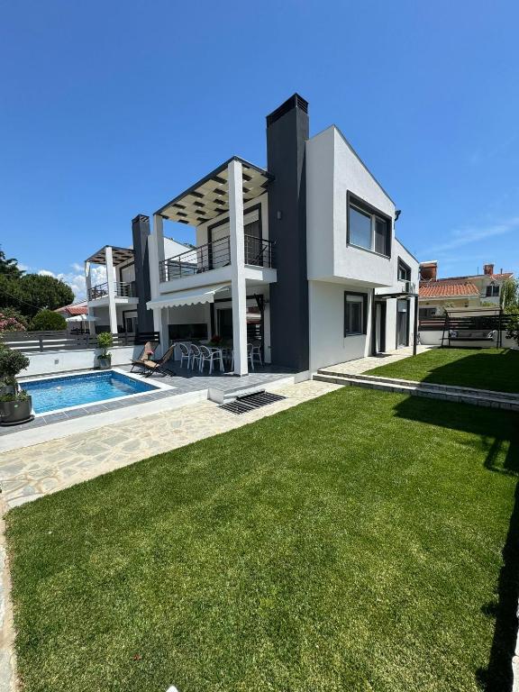 a villa with a swimming pool and a yard at Milena's Luxury Villa in Iraklitsa